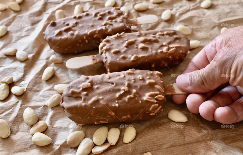 Summer treats: ice cream on a stick with chocolate and mandorle