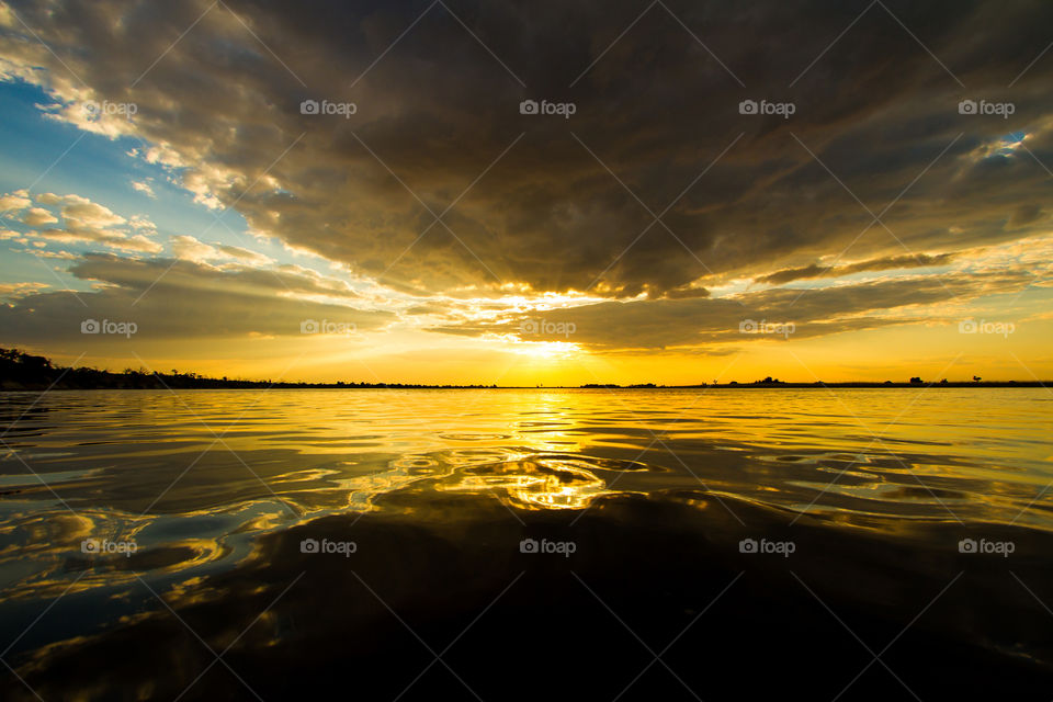 Beautiful golden sunset through the clouds at the Chobe river in Botswana, Africa. Sun rays over the water