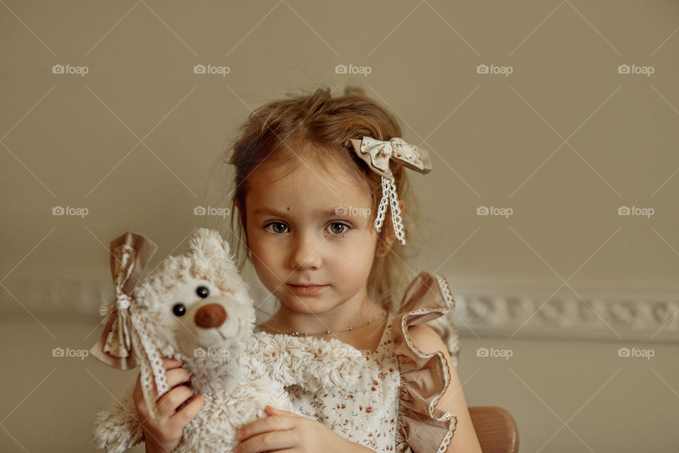 Vintage portrait of a beautiful little girl with teddy bear 