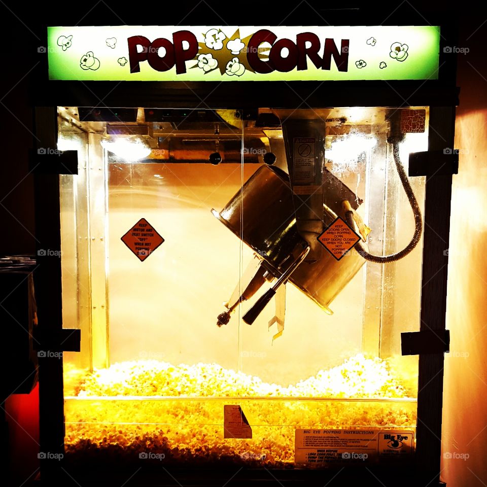 Popcorn machine at a movie theater provides hot and delicious snack.