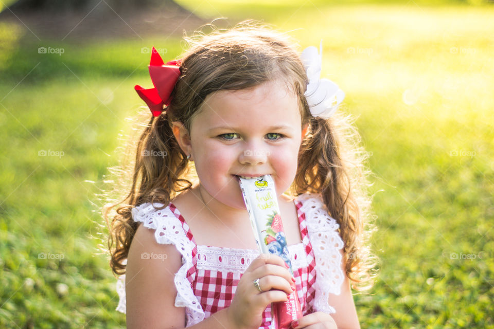 Young Girl in red and White Dress Eating Buddy Fruit Tube 4