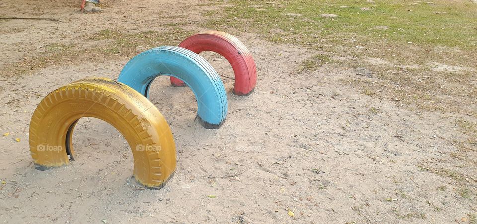 Playground, colored rubbers in the sand, circles, games for children.