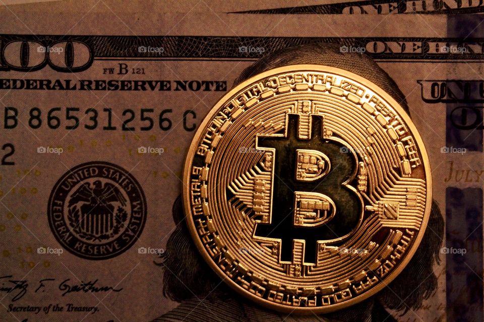 Bitcoin and a 100 dollar bill