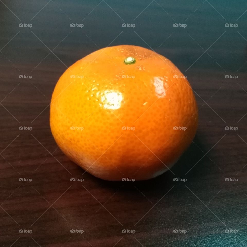Tangerine on a brown desk