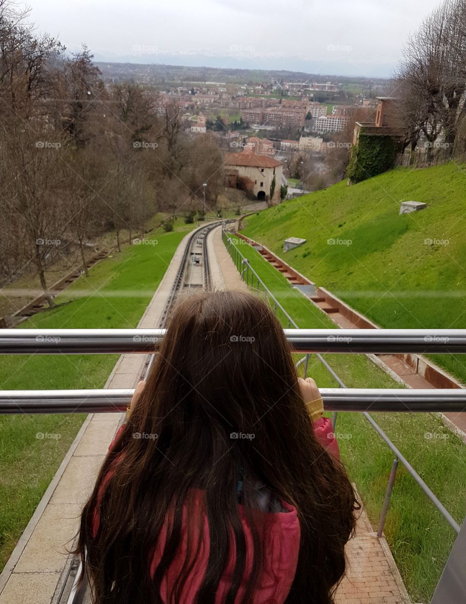 Little girl travelling with a funicular, admiring the landscape