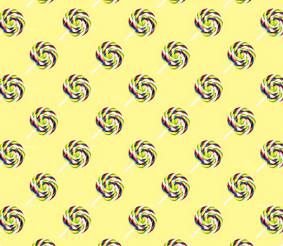 Colourful lollypop repeated against a yellow background in a diagonal pattern