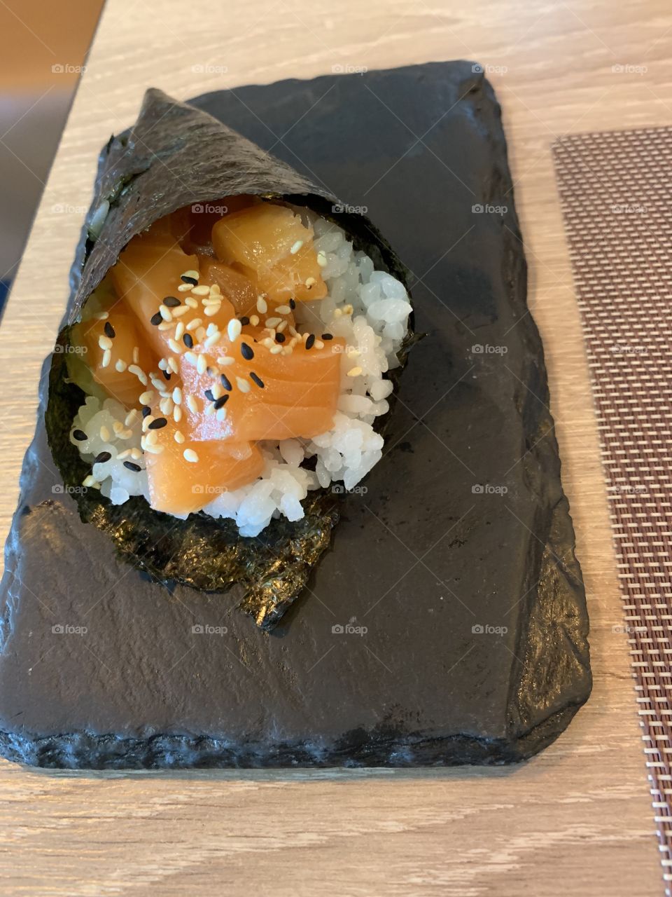Salmon temaki on top of a stone. Very beautifully presented
