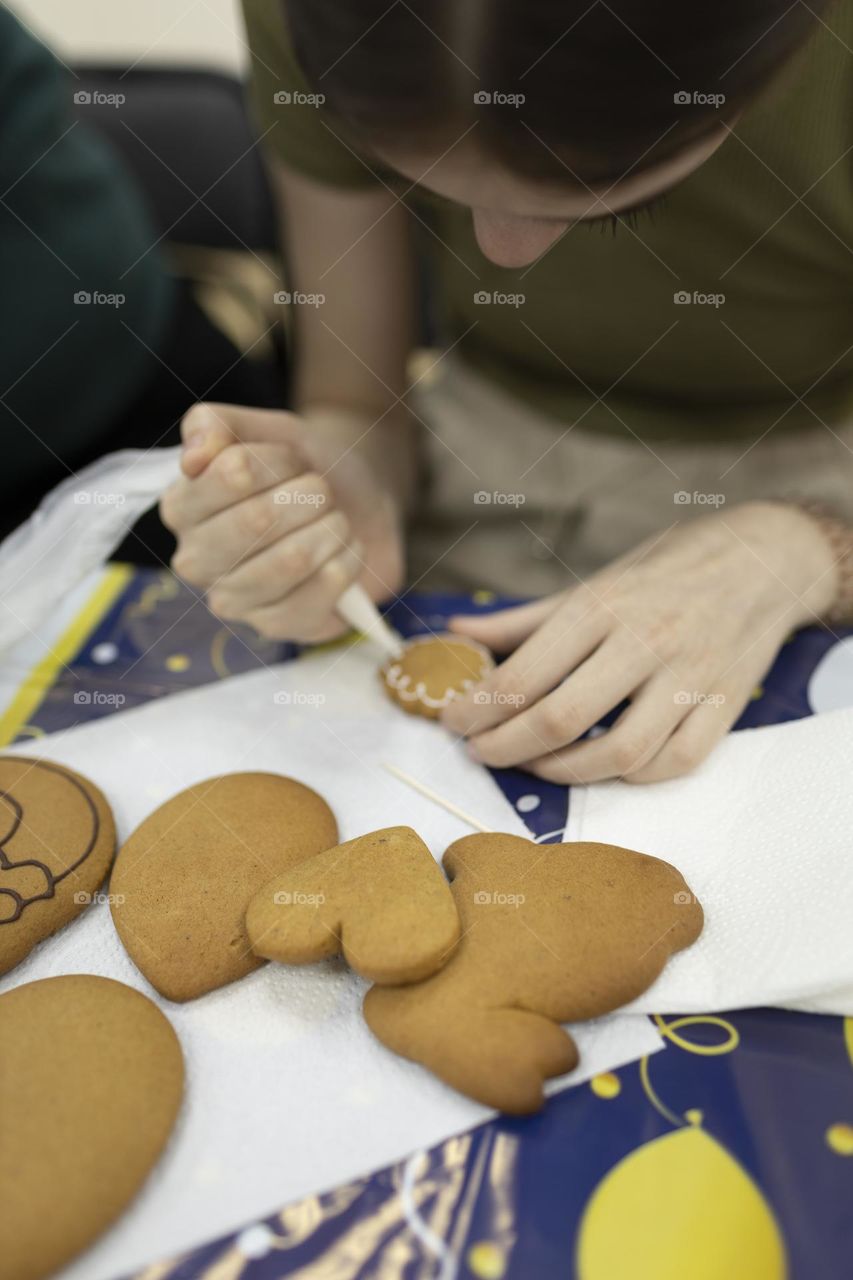 The child learns to paint gingerbread.

￼