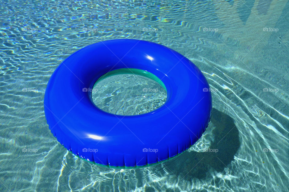 Blue pool float in a refreshing cool blue swimming pool.