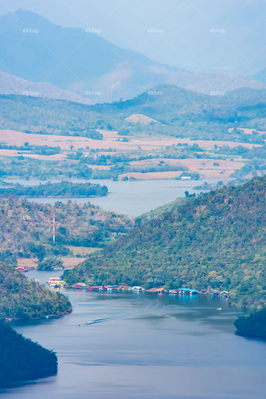 The beauty inside the dam and the houseboat on the bright sky at Sri Nakarin dam , Kanchana buri in Thailand.