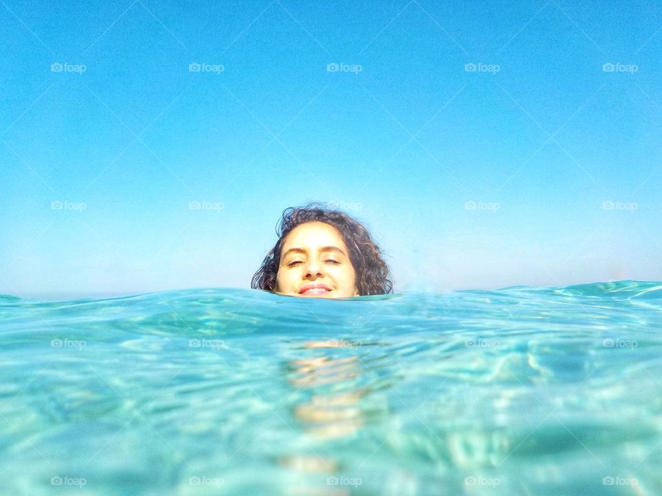 Smiling woman in the clear water of the sea