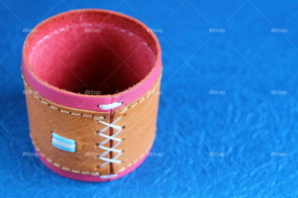 Leather strap of a perfume on a blue background