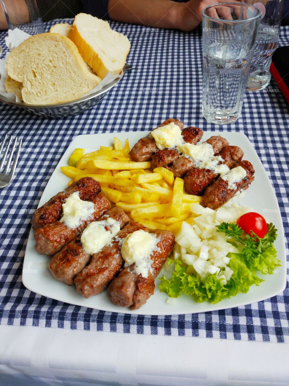 Kebab with french fries, lettuce and onion