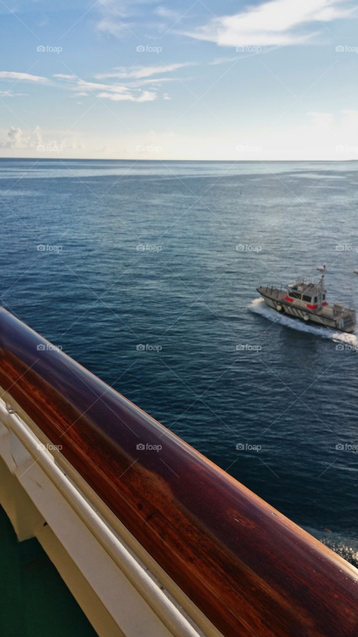 Pilot boat escorting ship out to sea