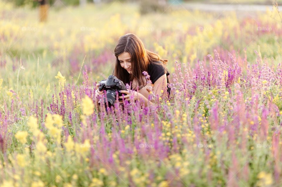 Woman in flower field with camera in hand