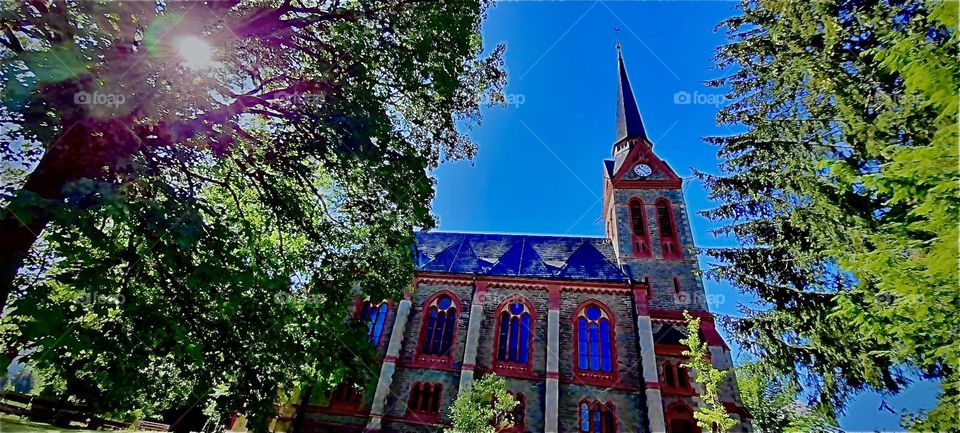 The majestic steeple of this cathedral in the Bavarian capital which is „Munich“ or „München“ as the locals call it pierces the bright blue sky on this lovely bright and sunny afternoon. 2022. Hypnotic Productions