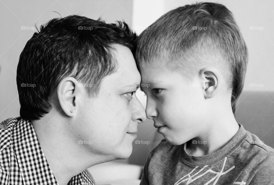 Father and son have fun together, look at each other at home, close-up portrait life style black and white photo