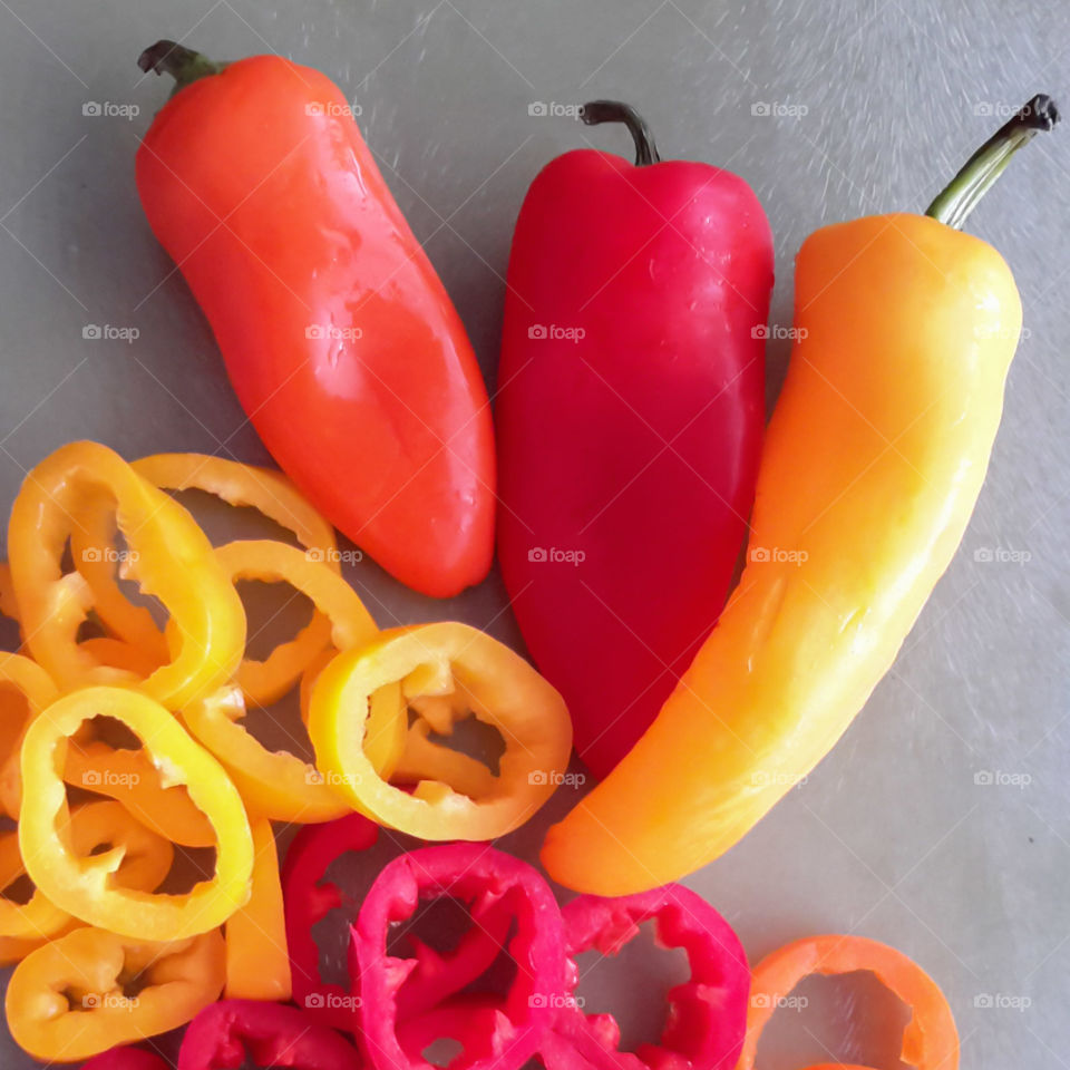 Colorful whole and sliced sweet peppers