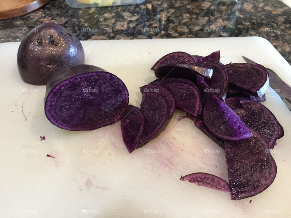 Purple potatoes that’s cut in half and sliced thinly for baking