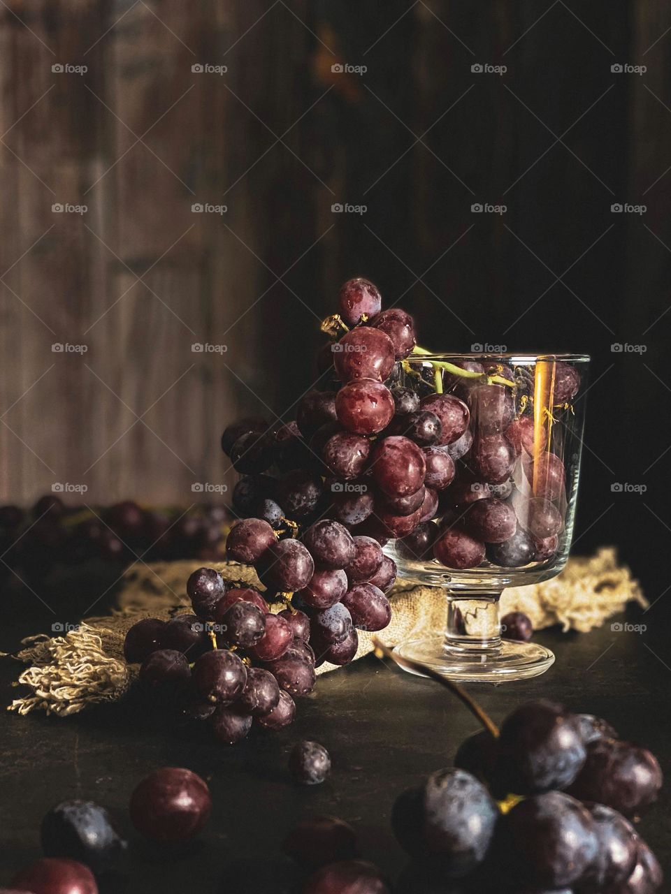 Still life image of fresh grapes on transparent glass. Dark photography.