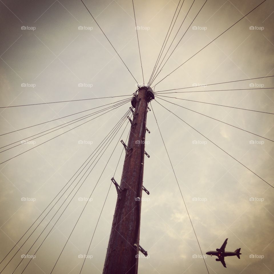 Shot of telegraph pole with plane in background