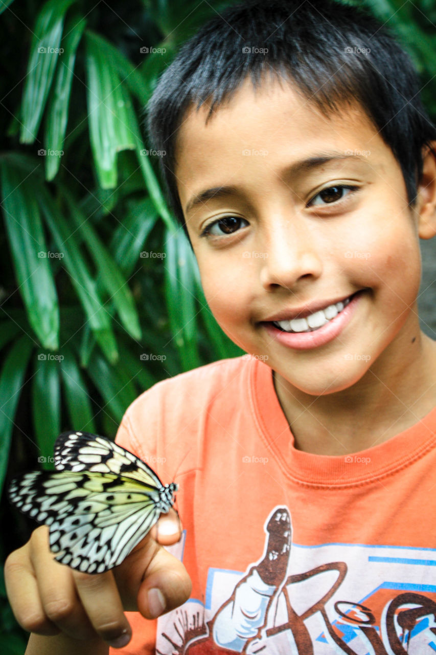 Boy is holding a butterfly