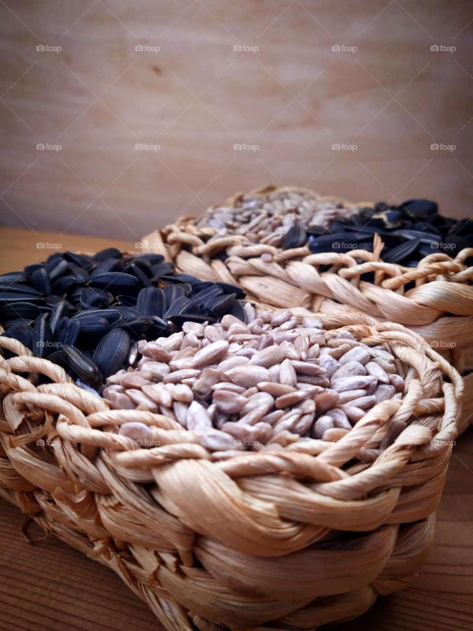 Two wicker baskets.  Each basket contains half sunflower seeds and half peeled sunflower seeds