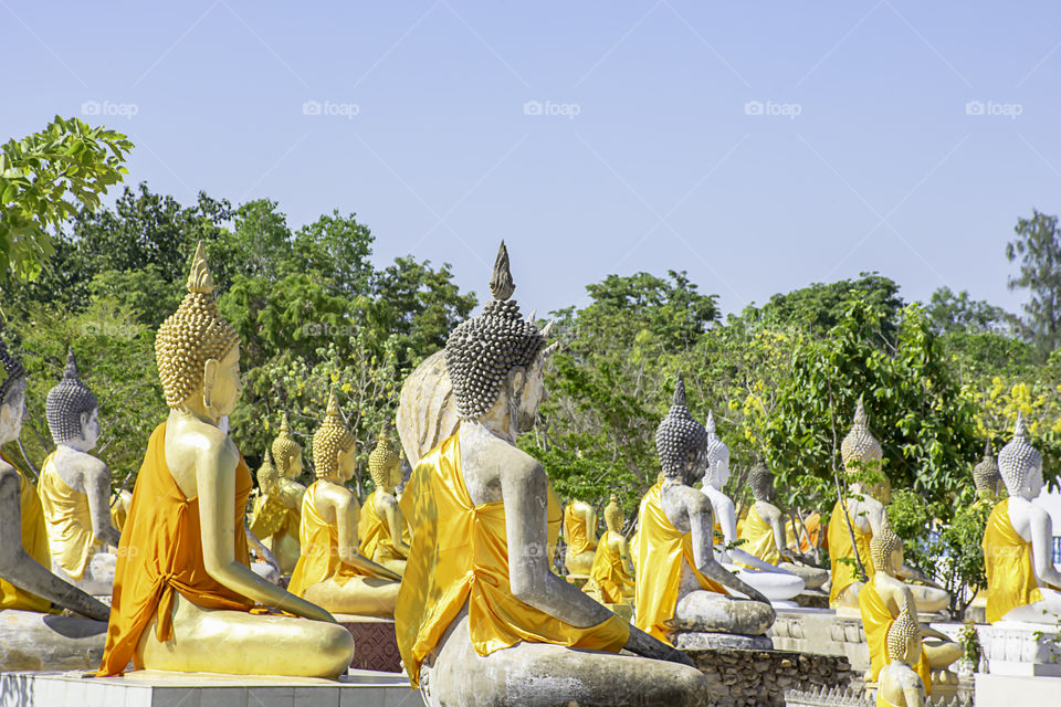 Behind the statue of Buddha  covered in yellow cloth Background sky at Wat Phai Rong Wua , Suphan Buri in Thailand.