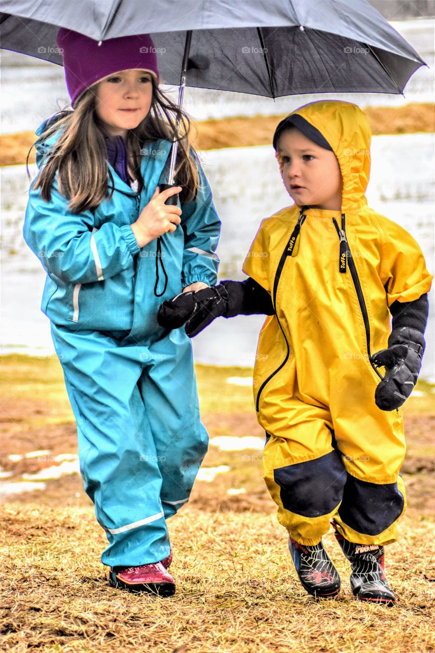 siblings outside in the rain