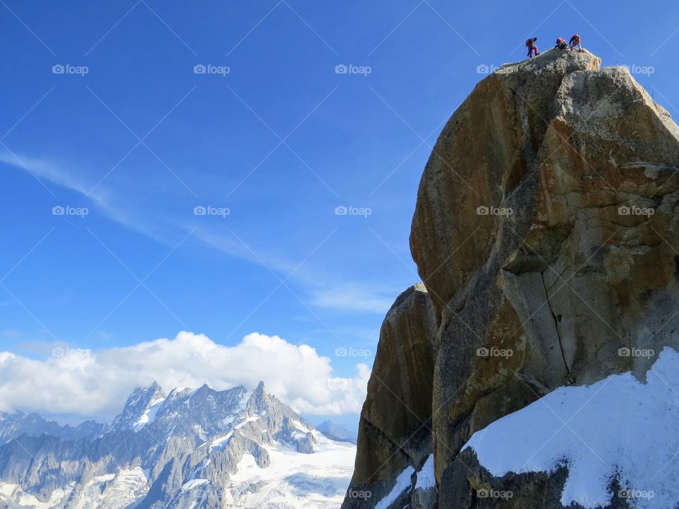 3 mountain climbers on top of the world