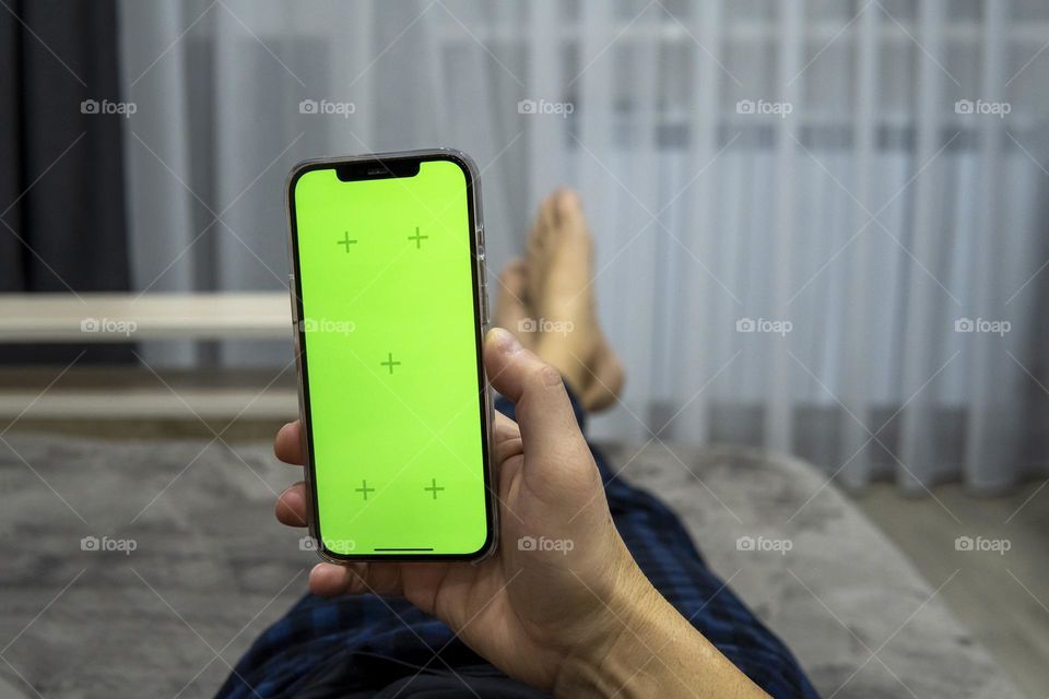 Man’s hands with smartphone. Rest on the sofa