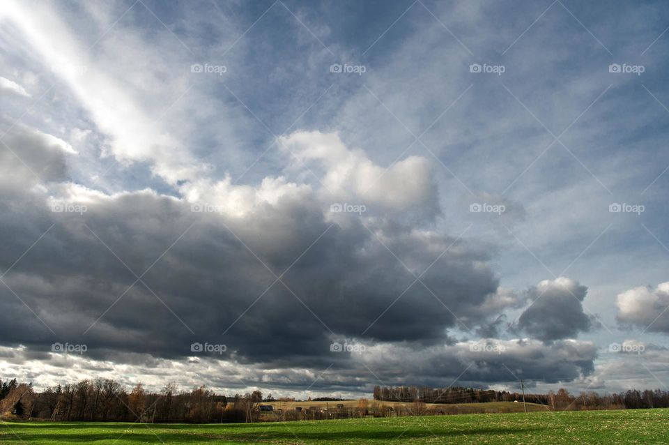 Dramatic sky with dark rsin clouds over of autumnal country landscape