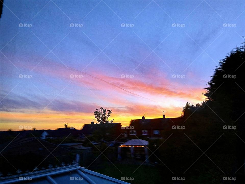 gorgeous sunset over some houses out of window