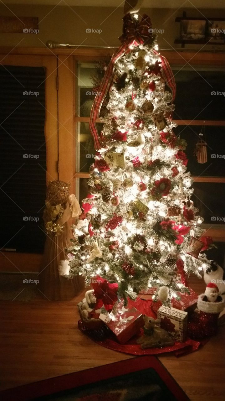 Traditional Tree Red and Green With Angel Next To It