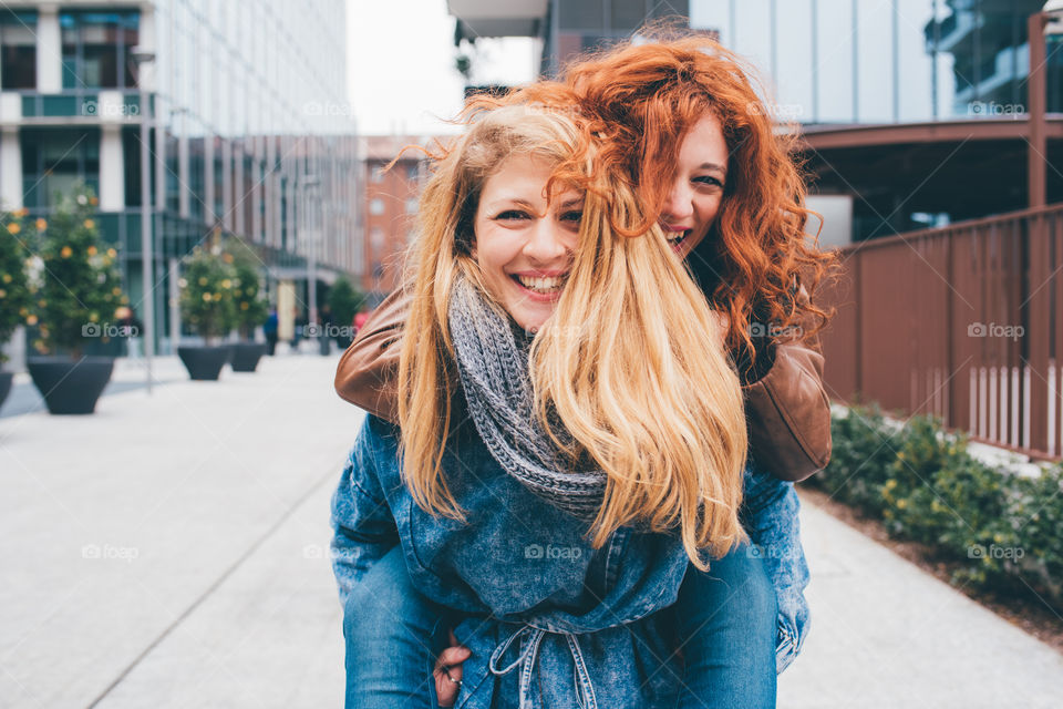 Two happy friends having fun in the city - happiness, freedom concepts