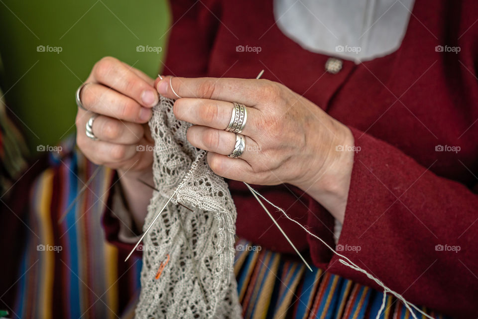 Close-up of the hands of an eldery woman knitting.