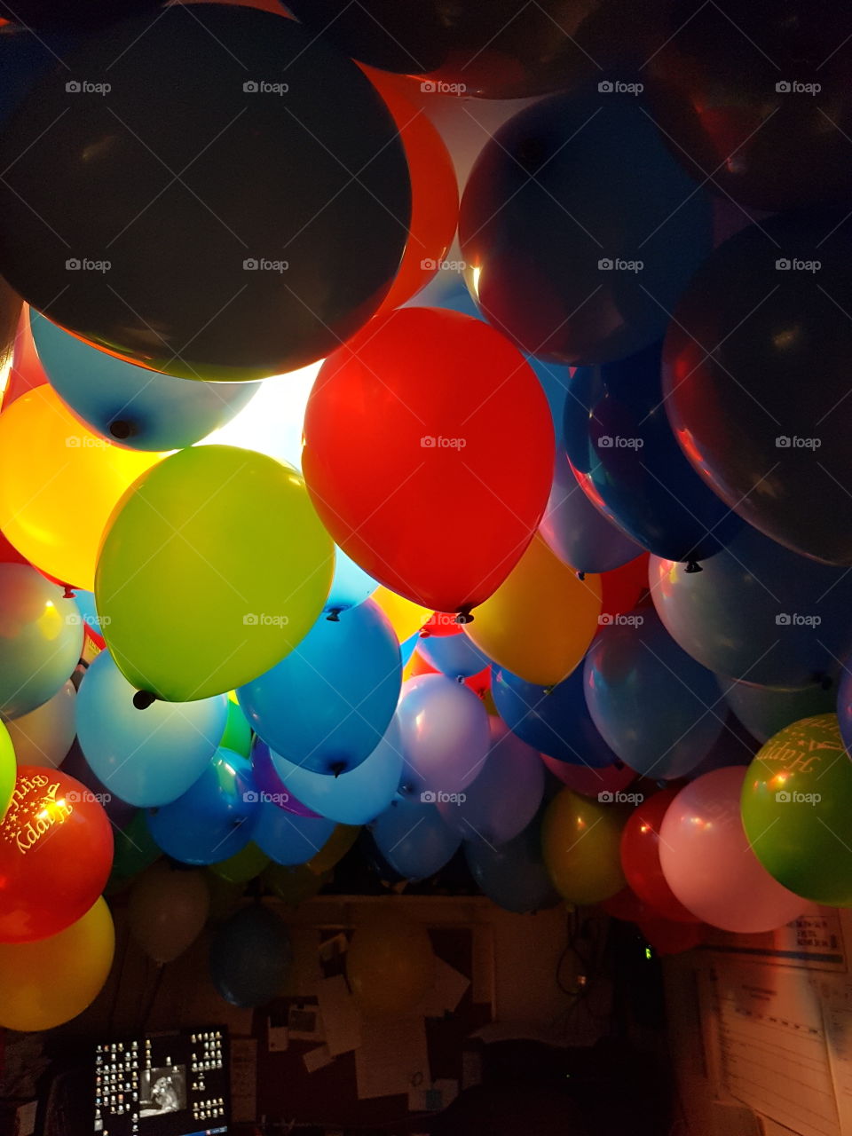Balloon overhaul! A green, blue, red, yellow birthday surprise in a small office space.