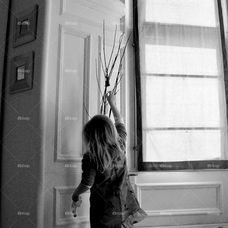 Rear view of child decorating the house