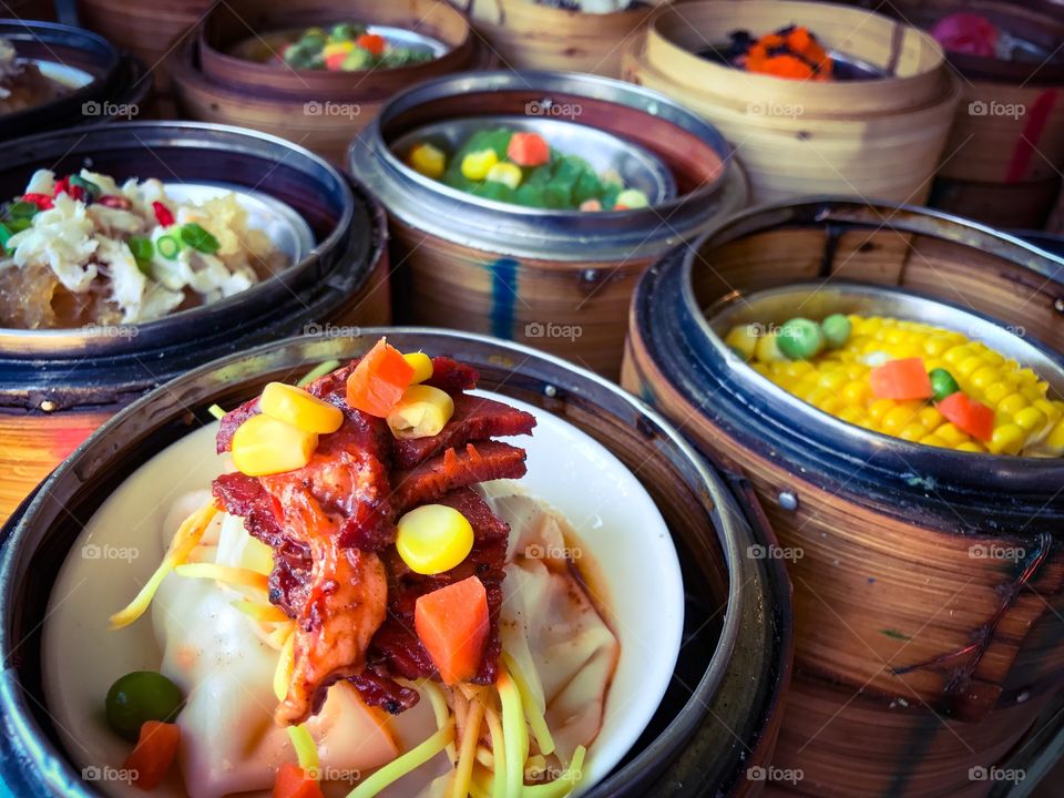 Breakfast set of traditional Chinese dim sum in steamed bamboo basket