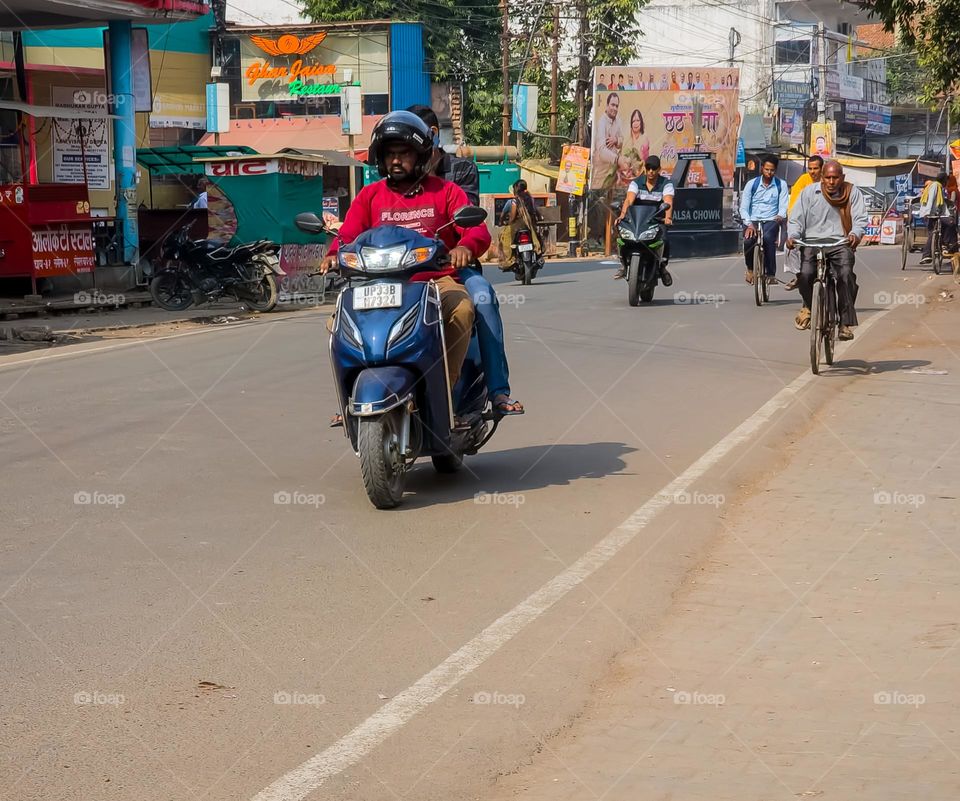 People on streets riding scooter and bicycle