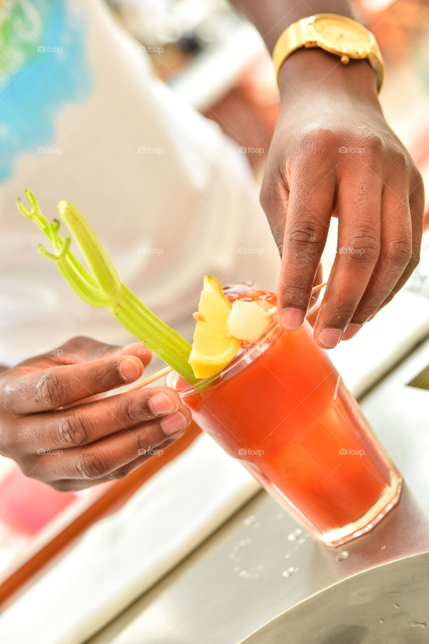 Close-up of a person's hand preparing cocktail