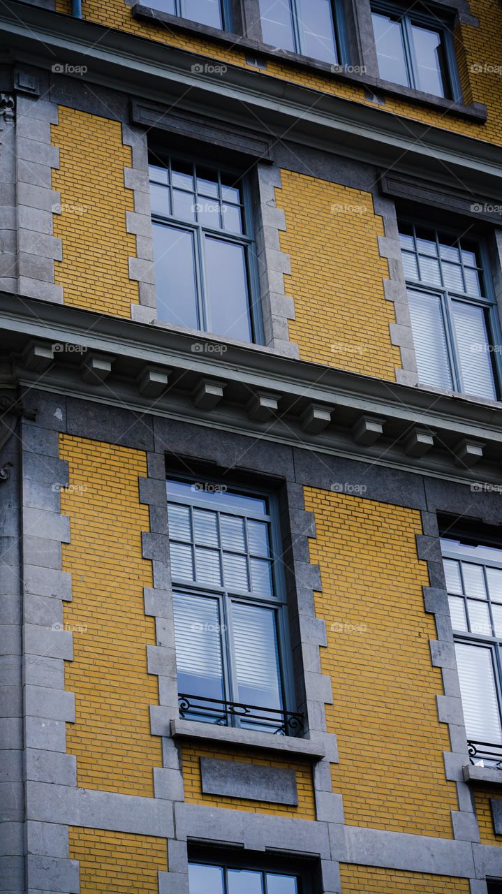 Facade with yellow bricks of a building in Antwerp, Belgium.