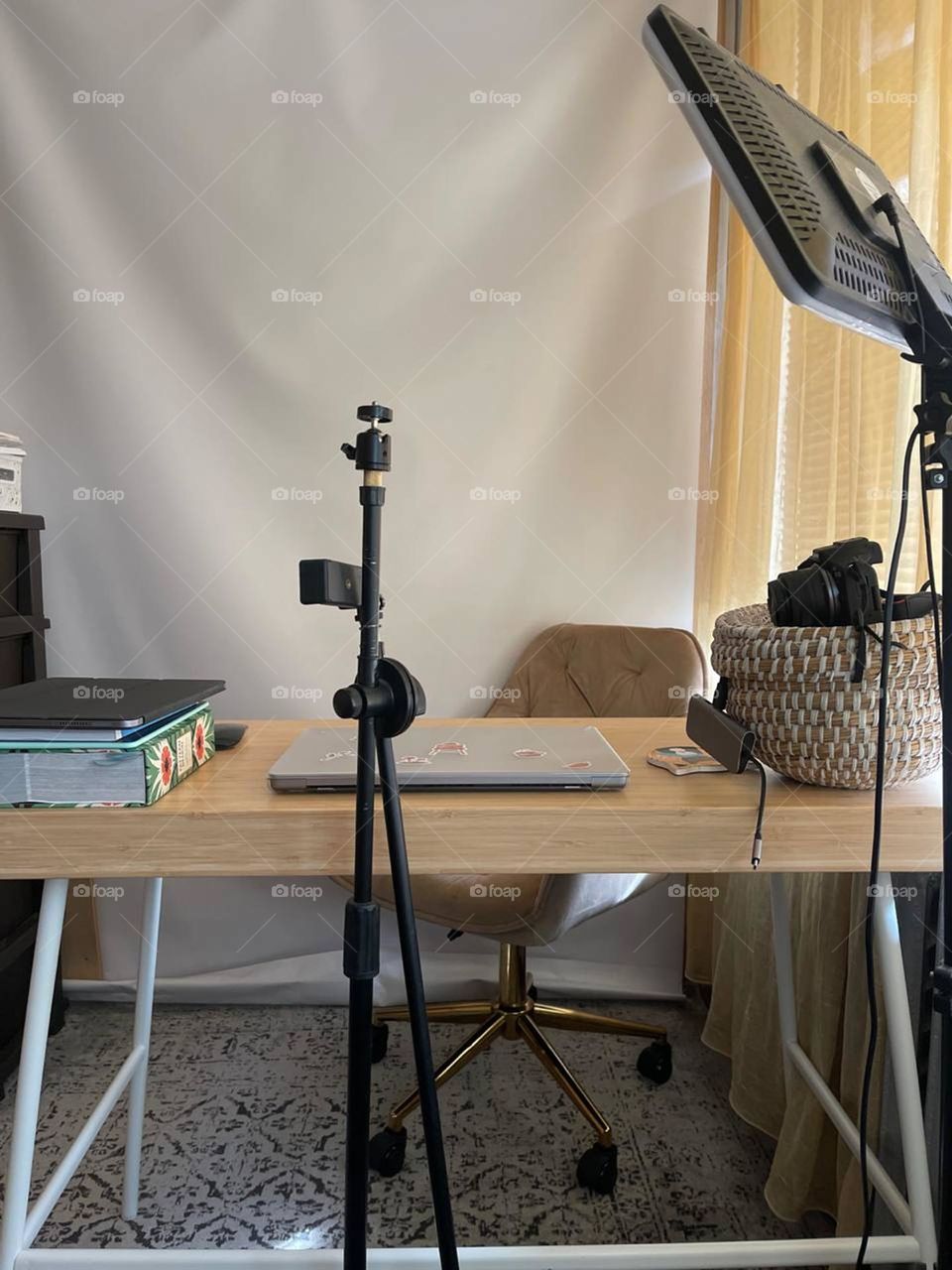 minimalist workplace of a blogger shooting a video with a laptop, notepad and a tripod for filming