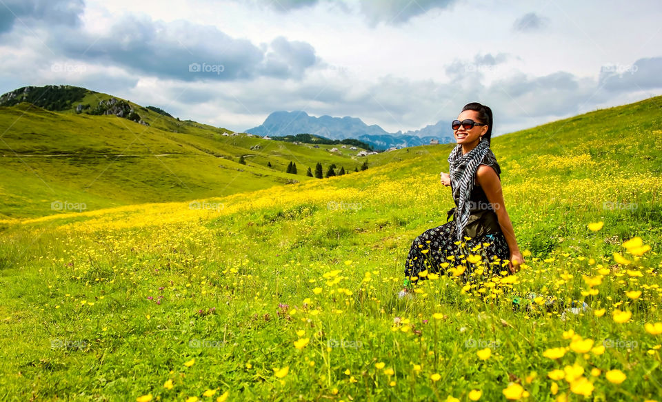 Woman wearing sunglasses in flower field at hill
