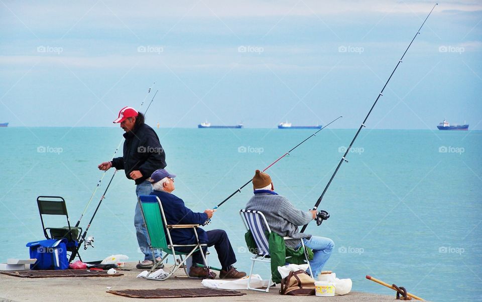 Two old friends are fishing and chatting in Mersin, Turkey