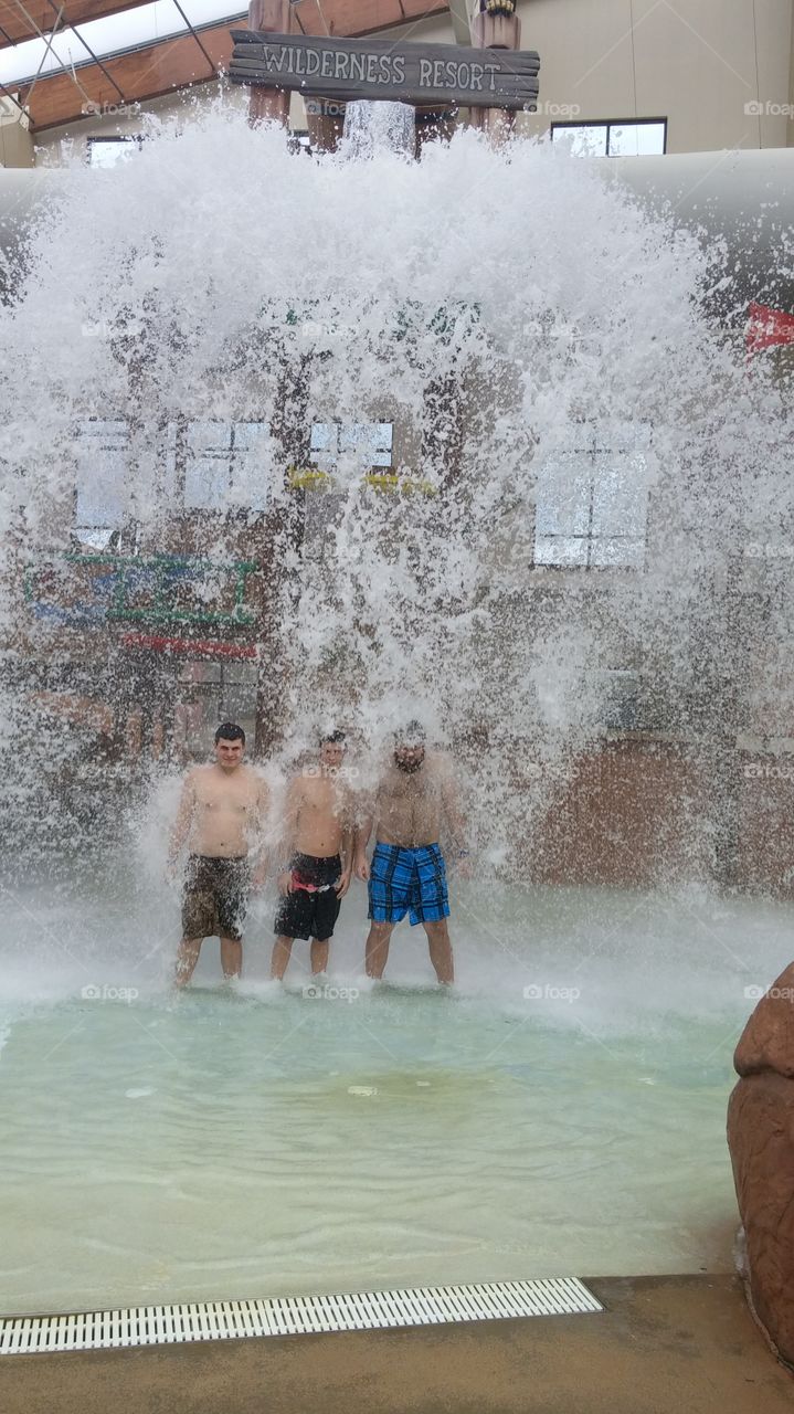 Friends enjoying water fall at resort