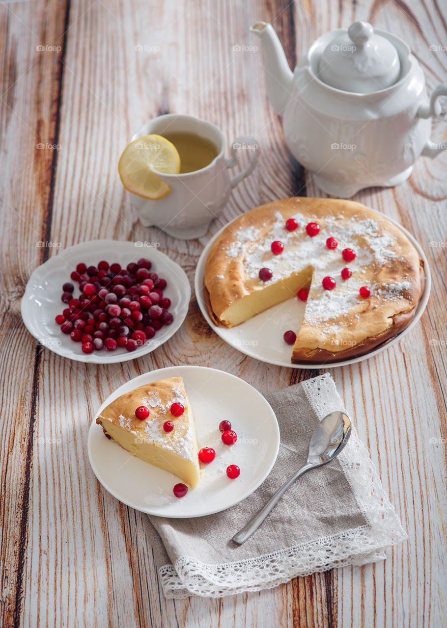 Cheesecake with cranberries and sugar on wooden background