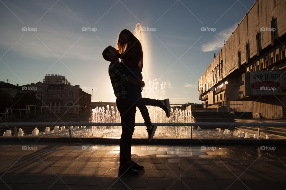 Silhouette of lovely pair. Boy hold his girl