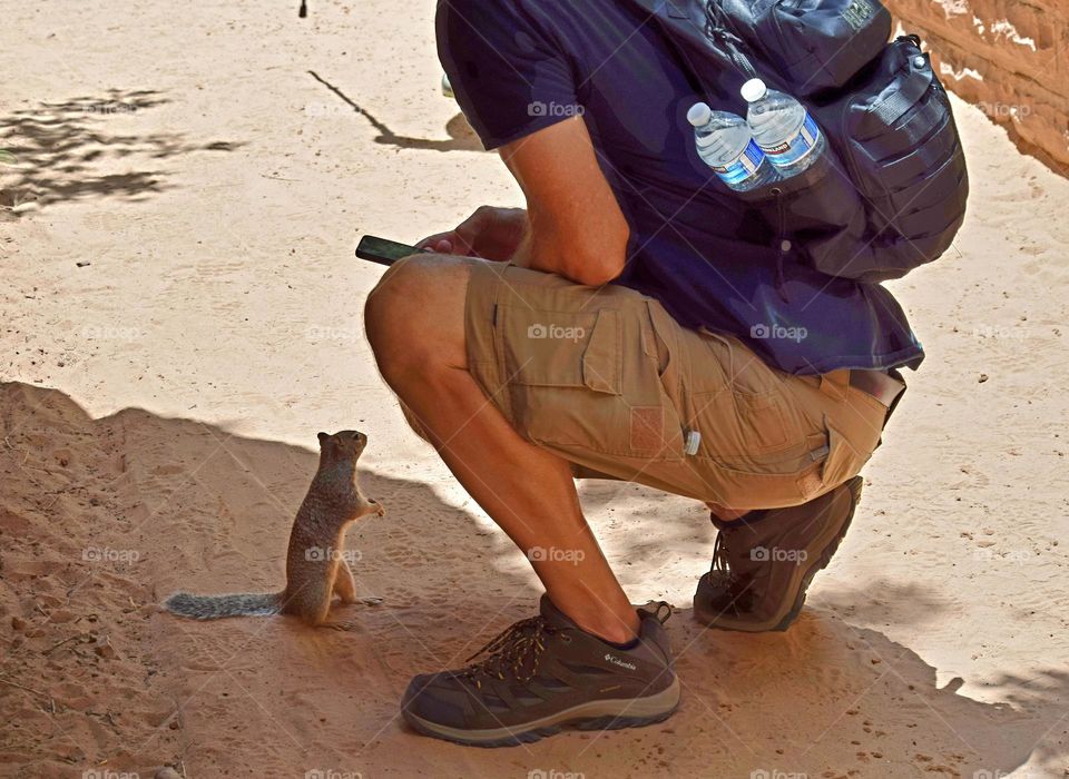 A man taking a photo of a squirrel