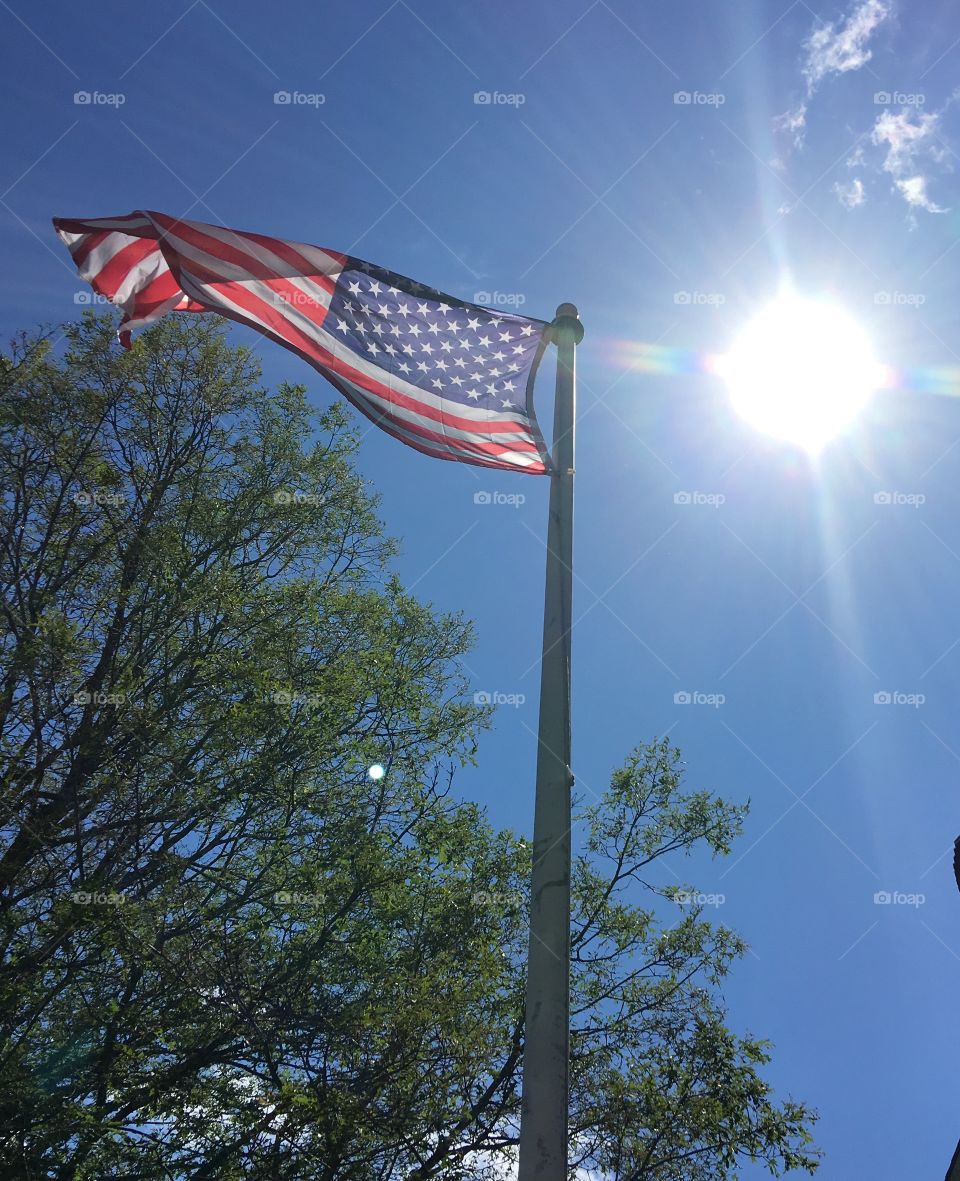 Sun shining on flag pole with Old Glory🇺🇸flag blowing in the wind!